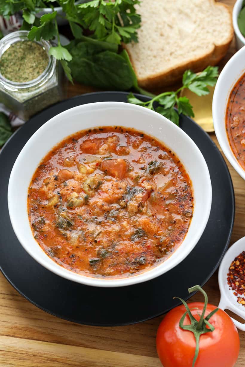 Haitian Bread Soup in white bowl with herbs