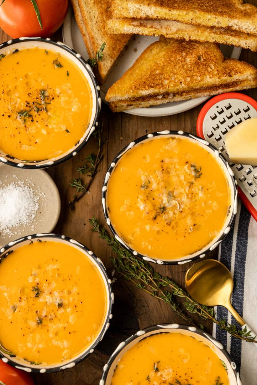 four bowls of tomato bisque and grilled cheese sandwich