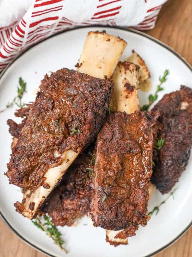 jerk ribs on white plate with herbs