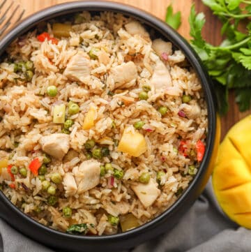 Mango Fried Rice in black bowl with mango on the side
