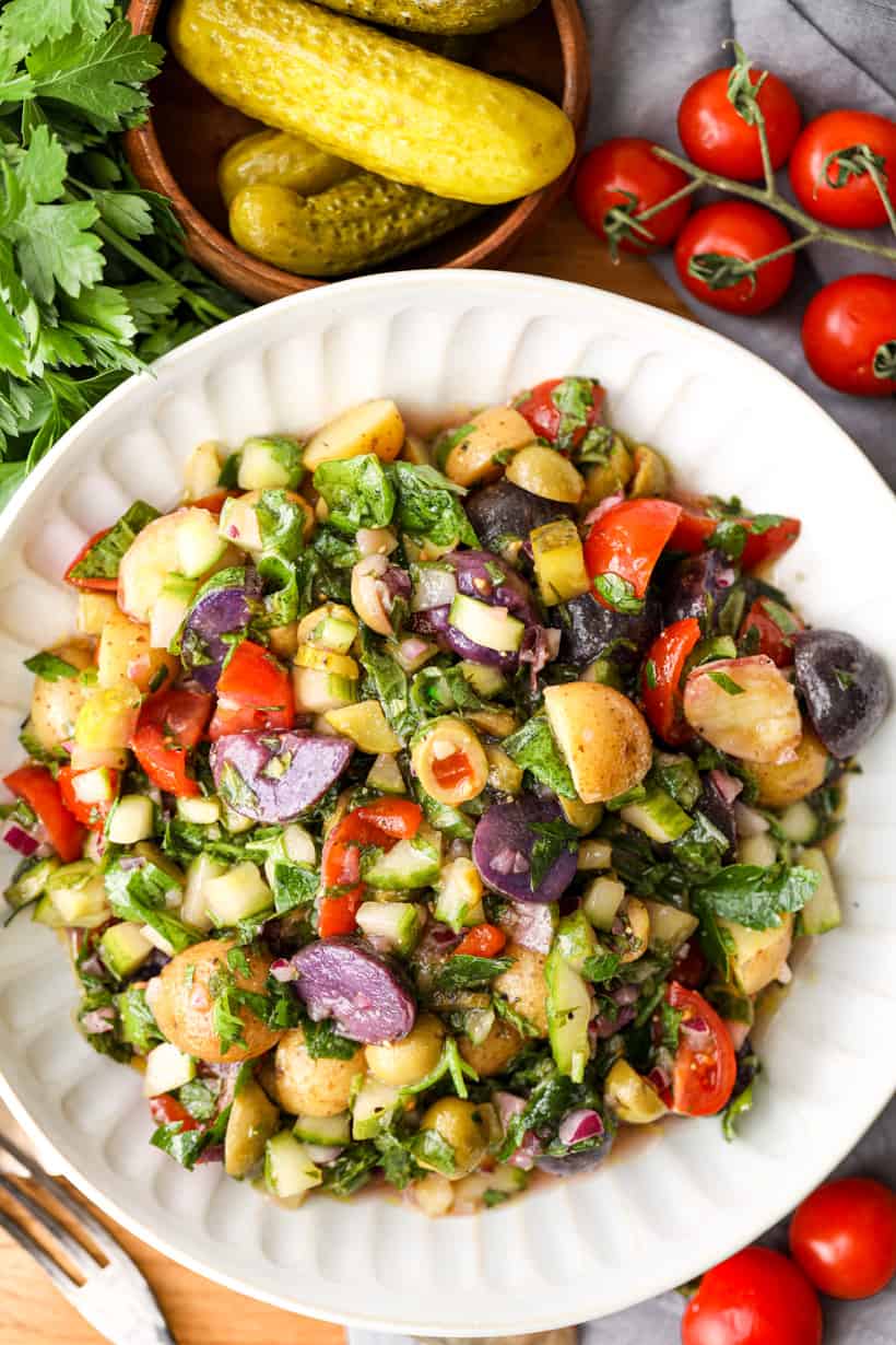 Mediterranean Potato Salad in white bowl with dill on the side