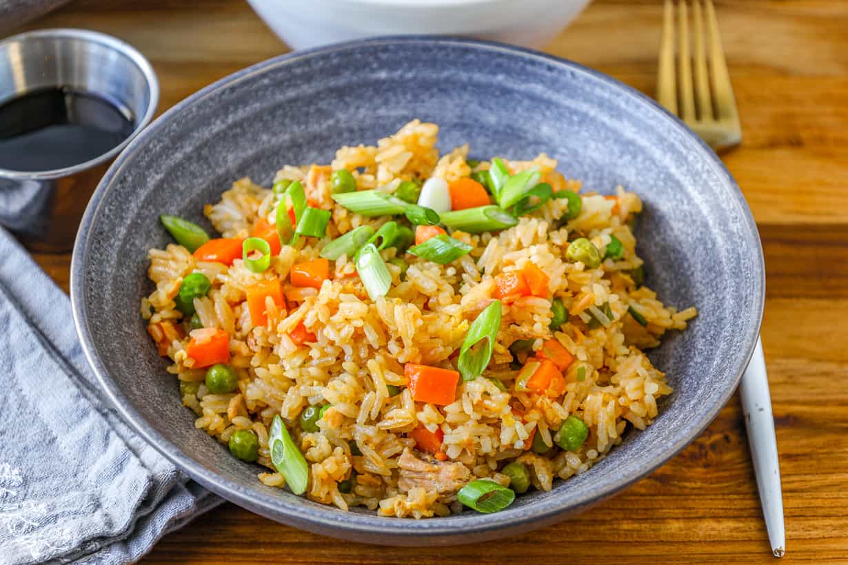 Tuna Fried rice topped with fresh green onions in a gray bowl.