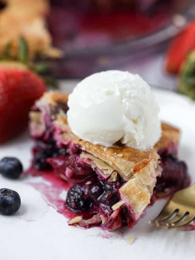 slice of strawberry blueberry pie with ice cream on top