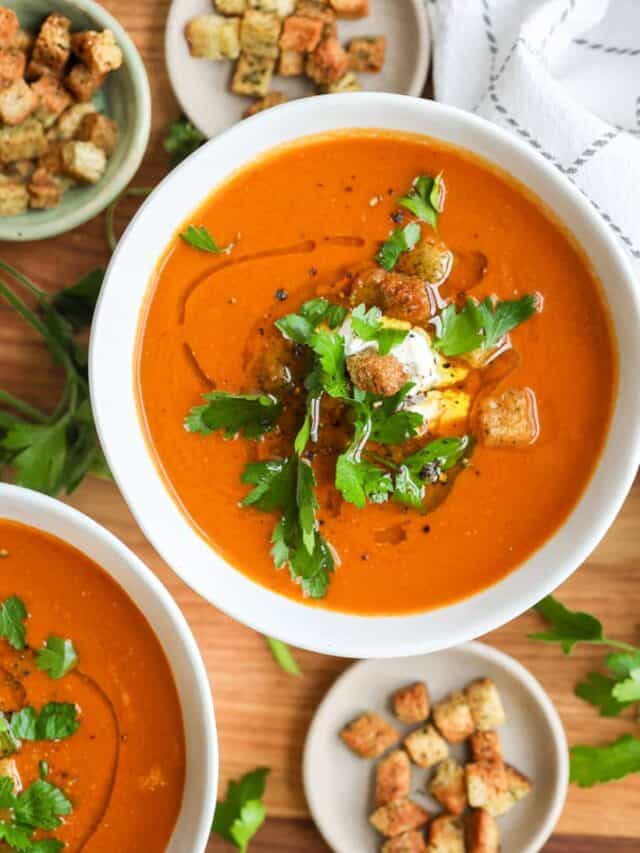 tomato basil bisque in two bowls with croups and garnished with fresh parsley