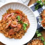 Cajun fried rice in white bowl and small blue bowls