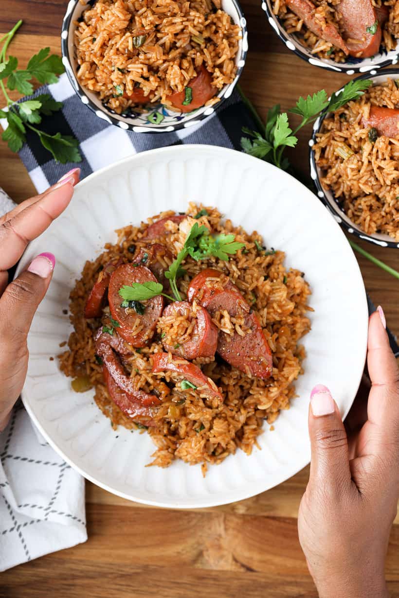 Hand-holding bowl filled with Cajun fried rice