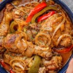 Poulet en sauce (Haitian Chicken Stew) in a bowl topped with onions and sweet peppers