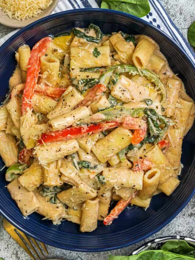 Rasta pasta in a blue bowl topped with fresh cracked peppers