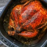 Air Fryer whole chicken in the air fryer basket.