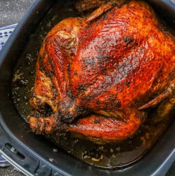 Air Fryer whole chicken in the air fryer basket.