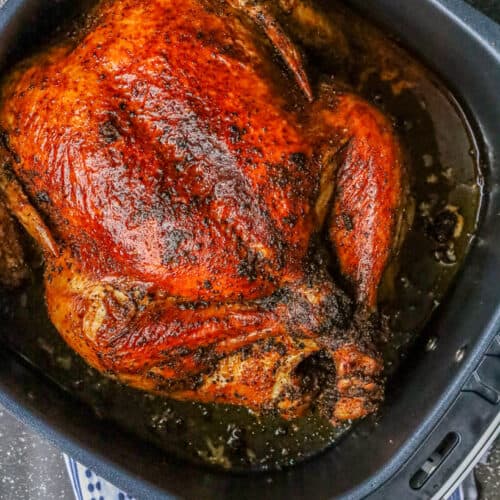 Air fryer whole chicken in the basket.