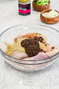 seasoning chicken with Delmas and jerk seasoning