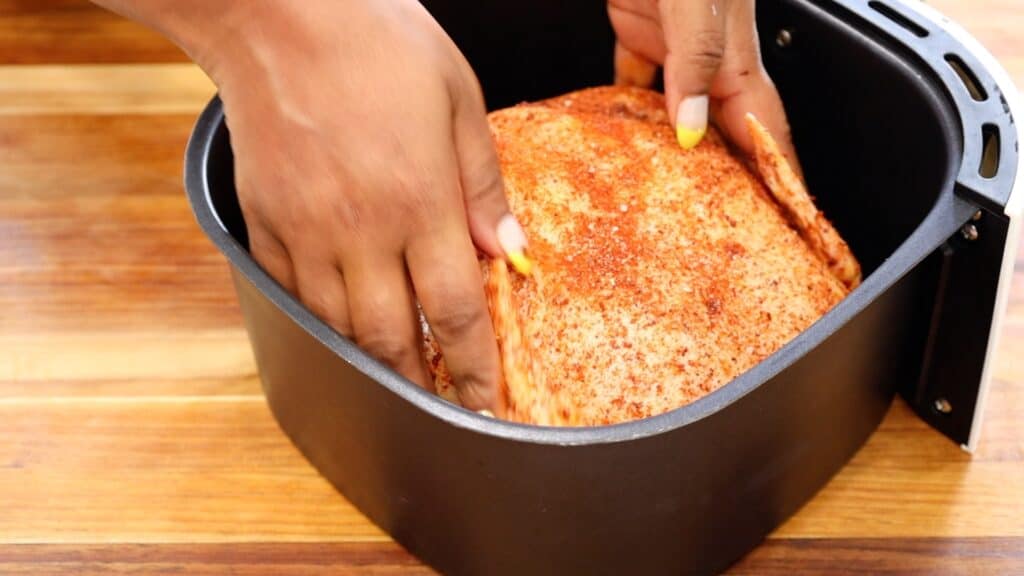 Placing Chicken in the air fryer basket