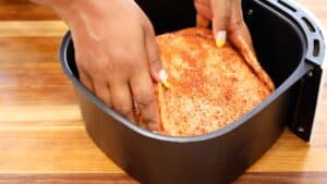 Placing Chicken in the air fryer basket