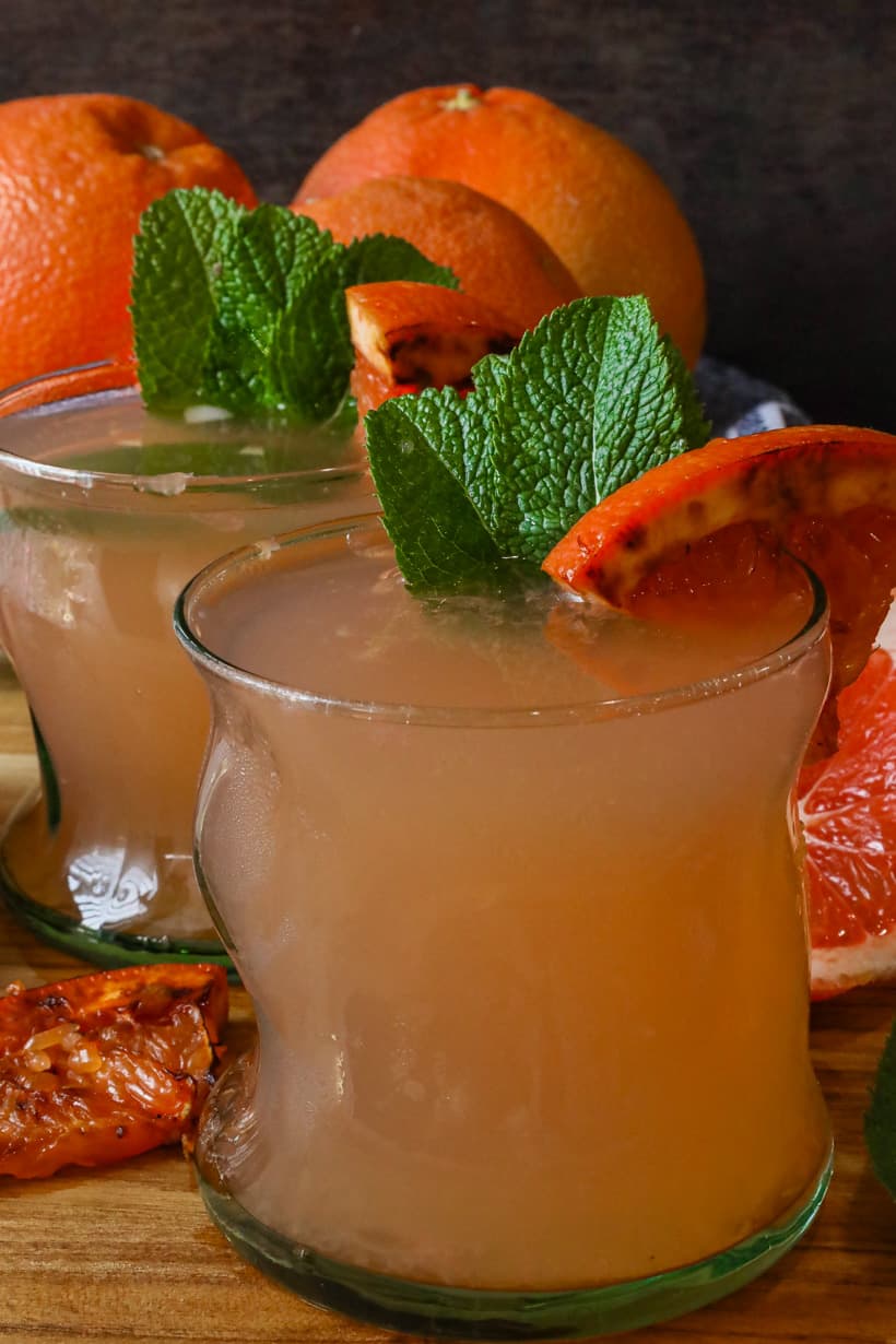 two glasses of grapefruit juice with caramelized grapefruit and fresh mint leaves