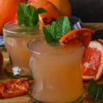 two glasses of grapefruit juice with caramelized grapefruit and fresh mint leaves
