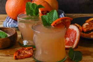 two glasses of grapefruit juice with caramelized grapefruit and fresh mint leaves