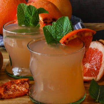 two glasses of grapefruit juice with caramelized grapefruit and fresh mint leaves