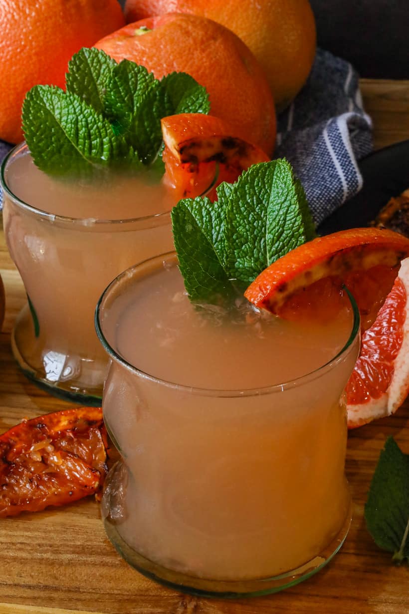 two glasses of grapefruit juice with caramelized grapefruit and fresh mint leaves