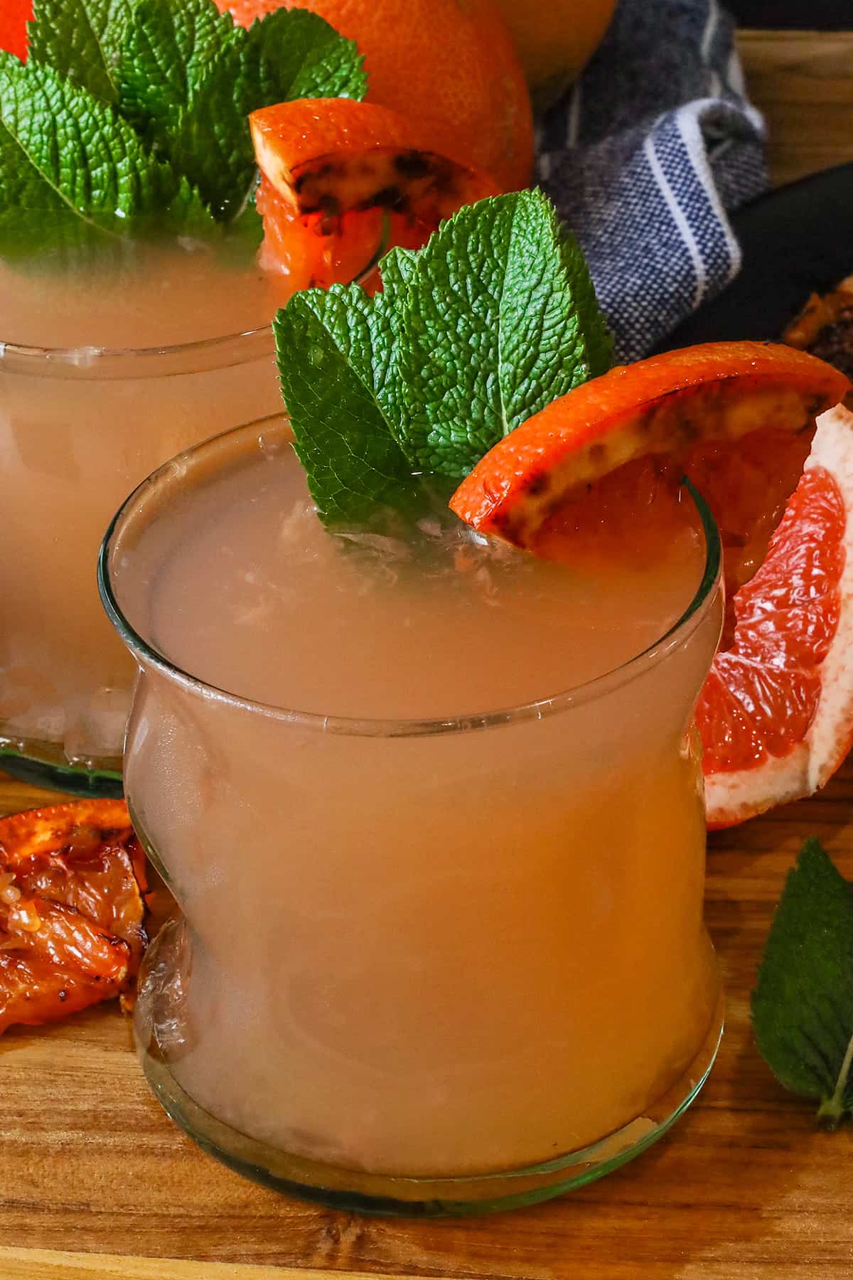 two glasses of grapefruit juice with caramelized grapefruit and fresh mint leaves