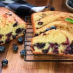 Slices of blueberry loaf cake on cooling rack