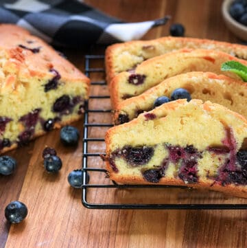 Slices of blueberry loaf cake on cooling rack