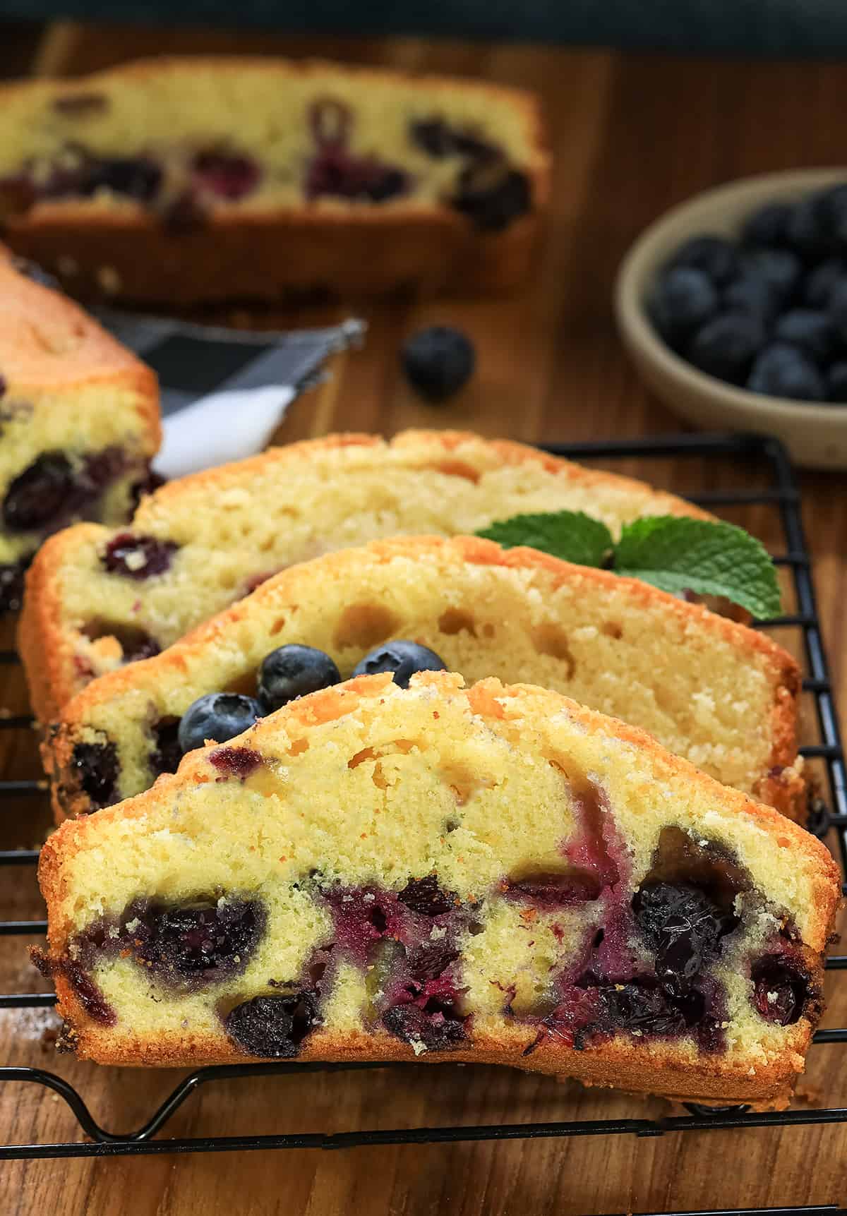 Blueberry loaf cake cup in slices on cooling rack