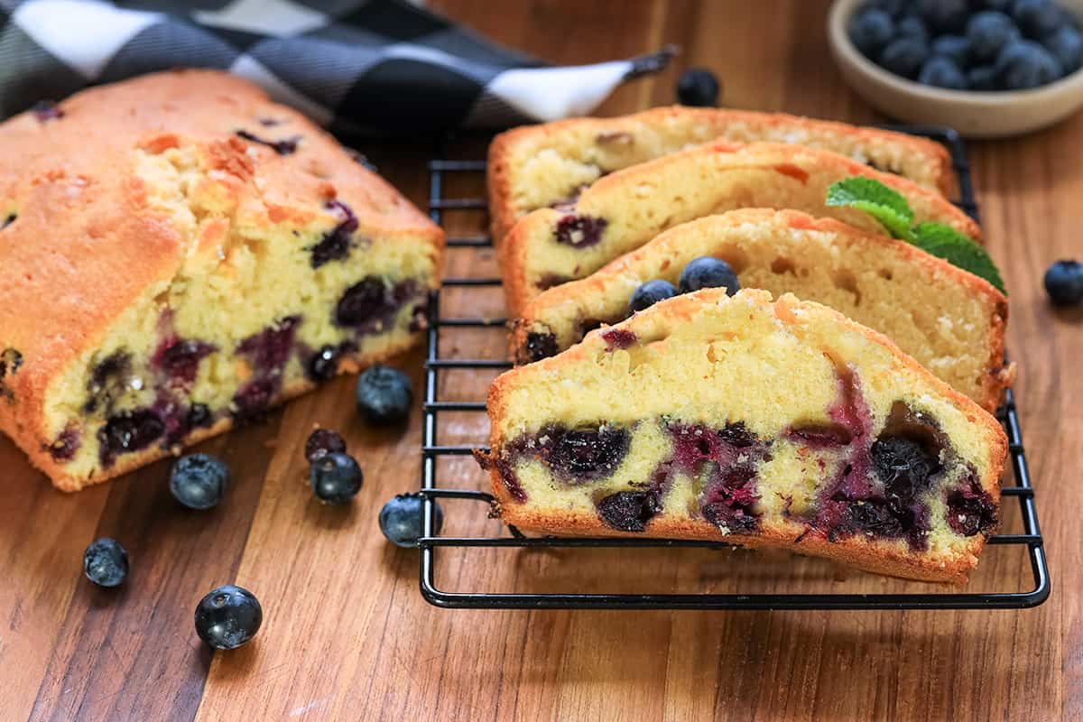 Slices of blueberry loaf cake on cooling rack