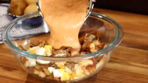 Adding dressing to potatoes and eggs