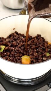 Adding water to beans and vegetables