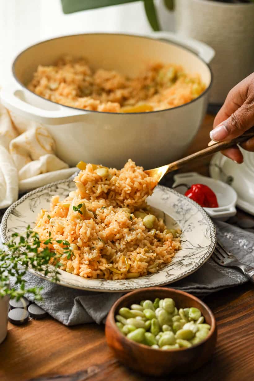 hand holding spoonful of lima beans and rice