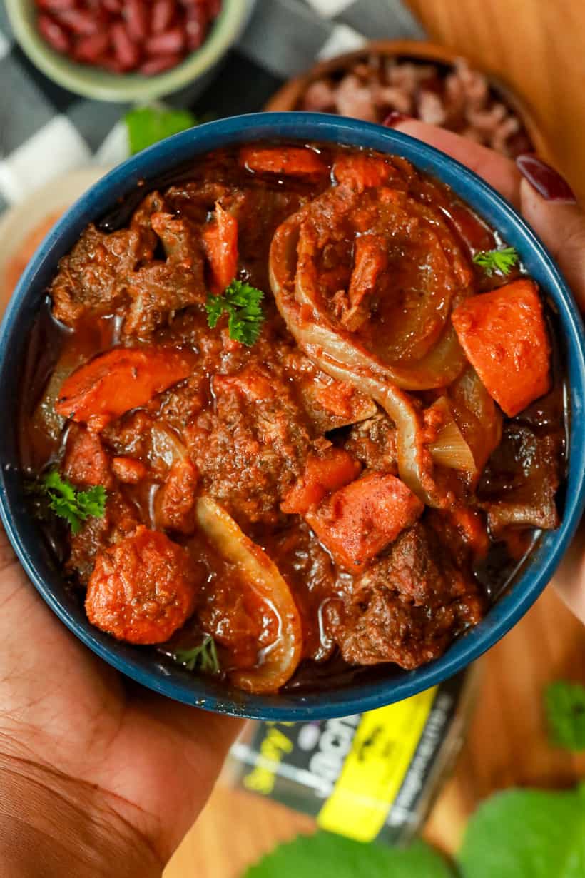 Hand holding Haitian Beef Stew / Sauce