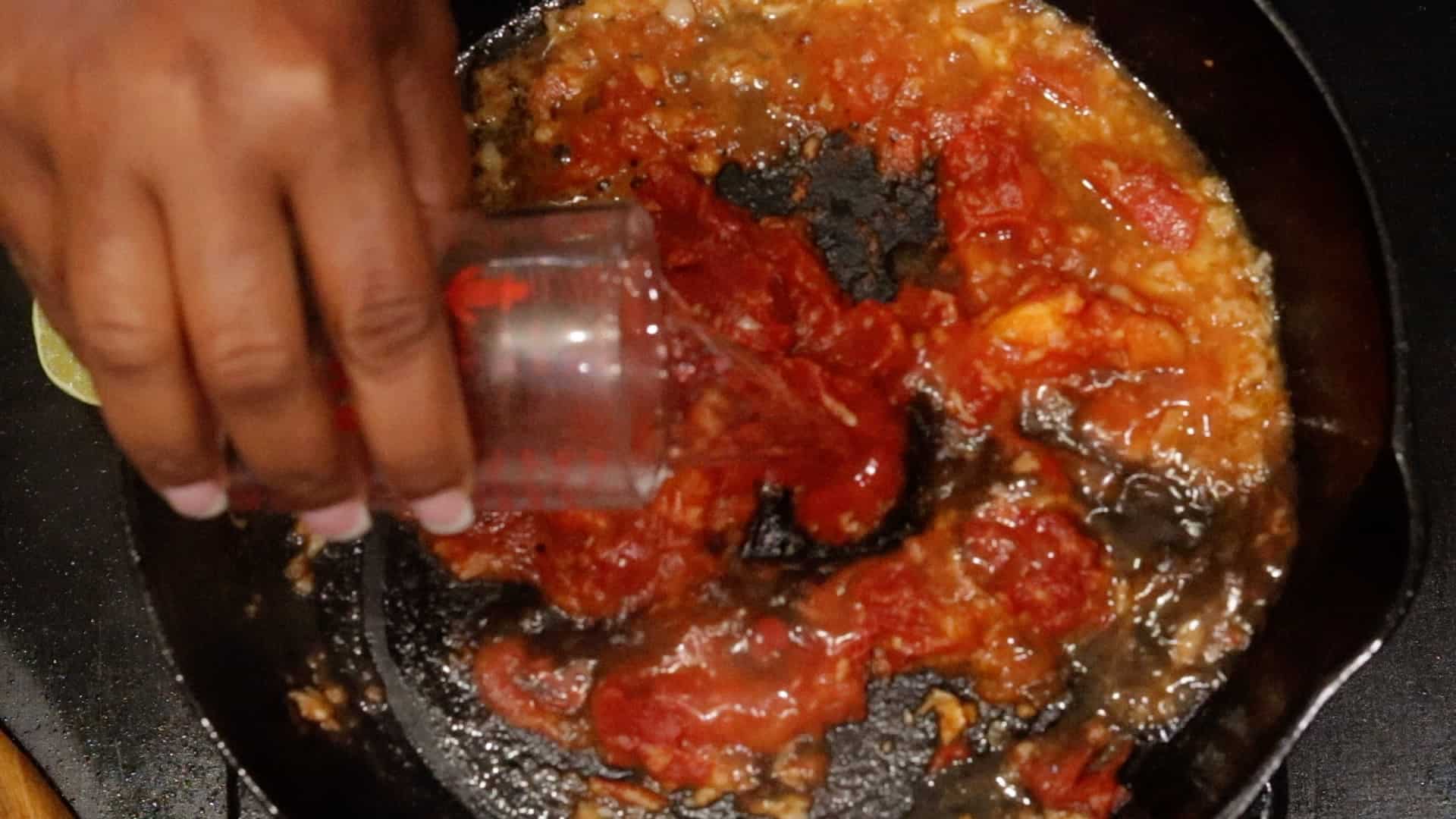 Pouring in liquid to tomato mixture