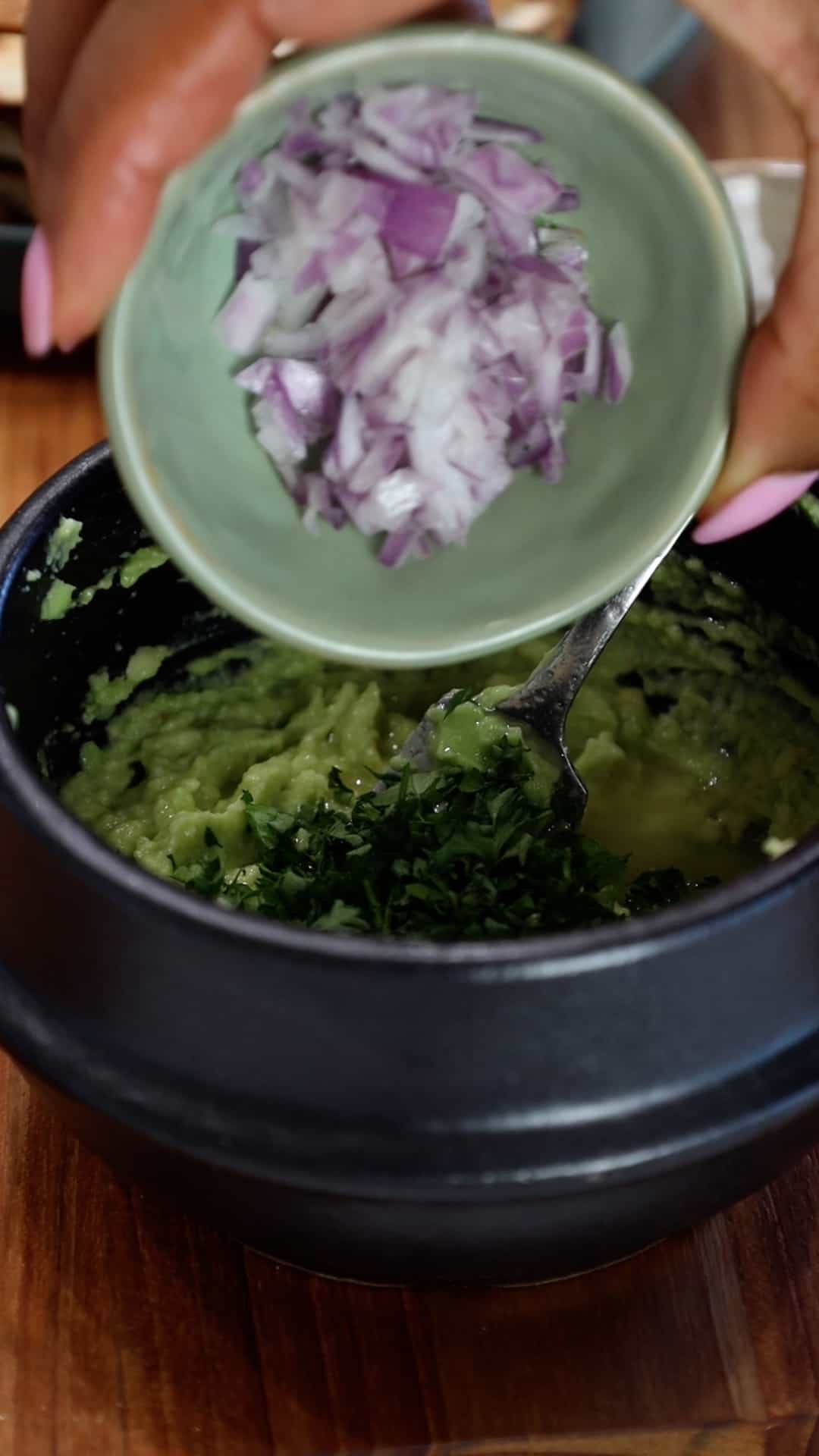 adding onions to avocado
