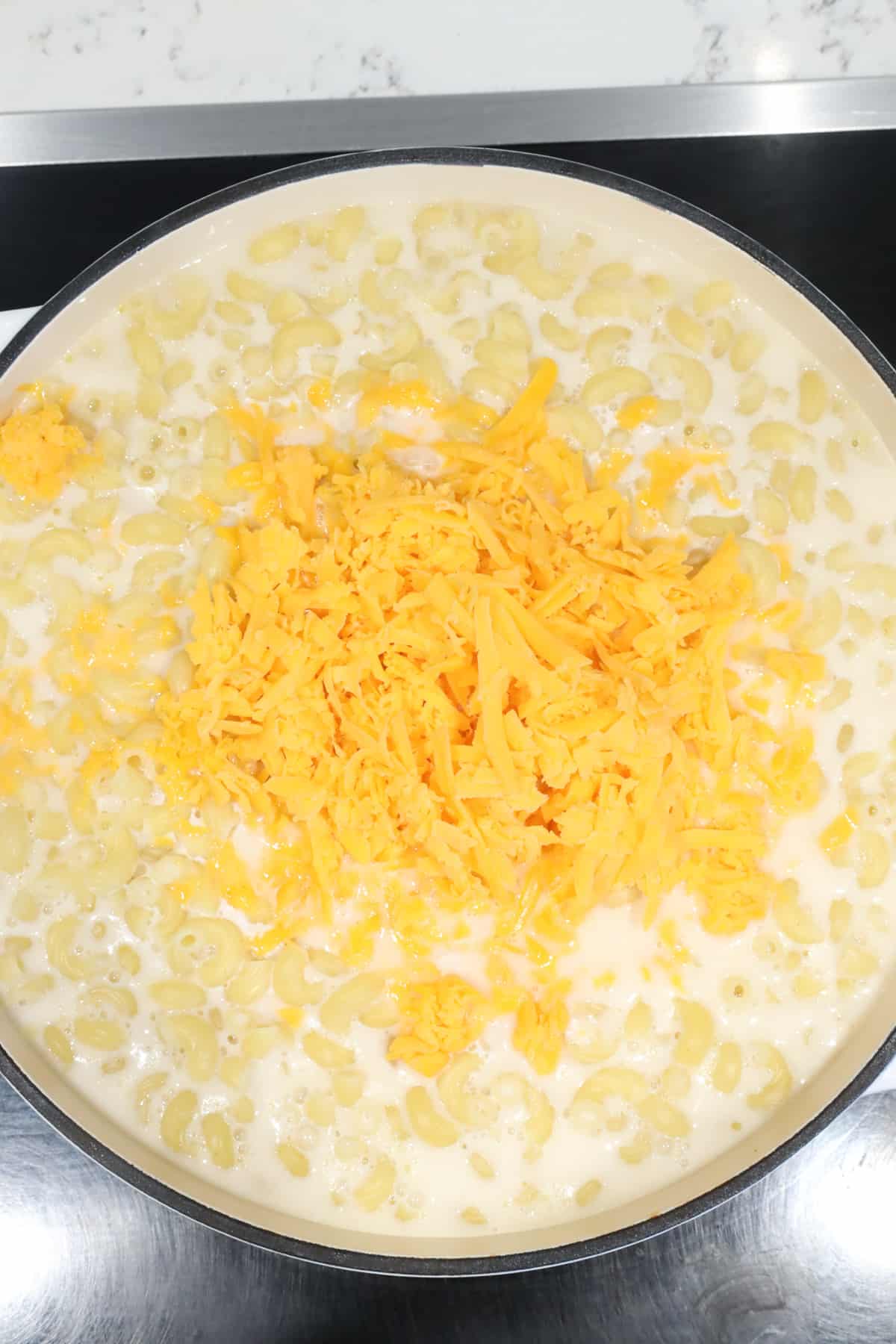 adding cheese to macaroni