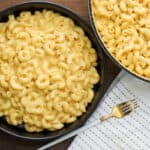 Mac and cheese with fork on a wooden board