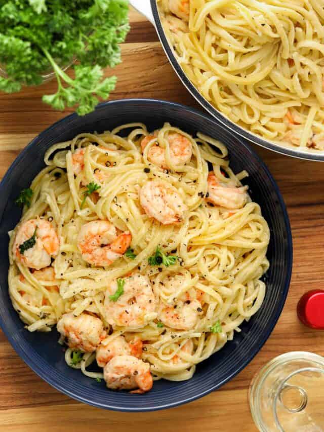 shrimp scampi with linguine in blue bowl and fresh hers with glass of wine.