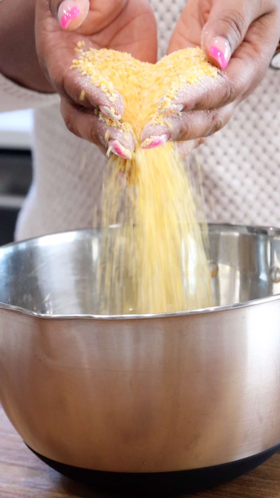 dropping cornmeal in bowl