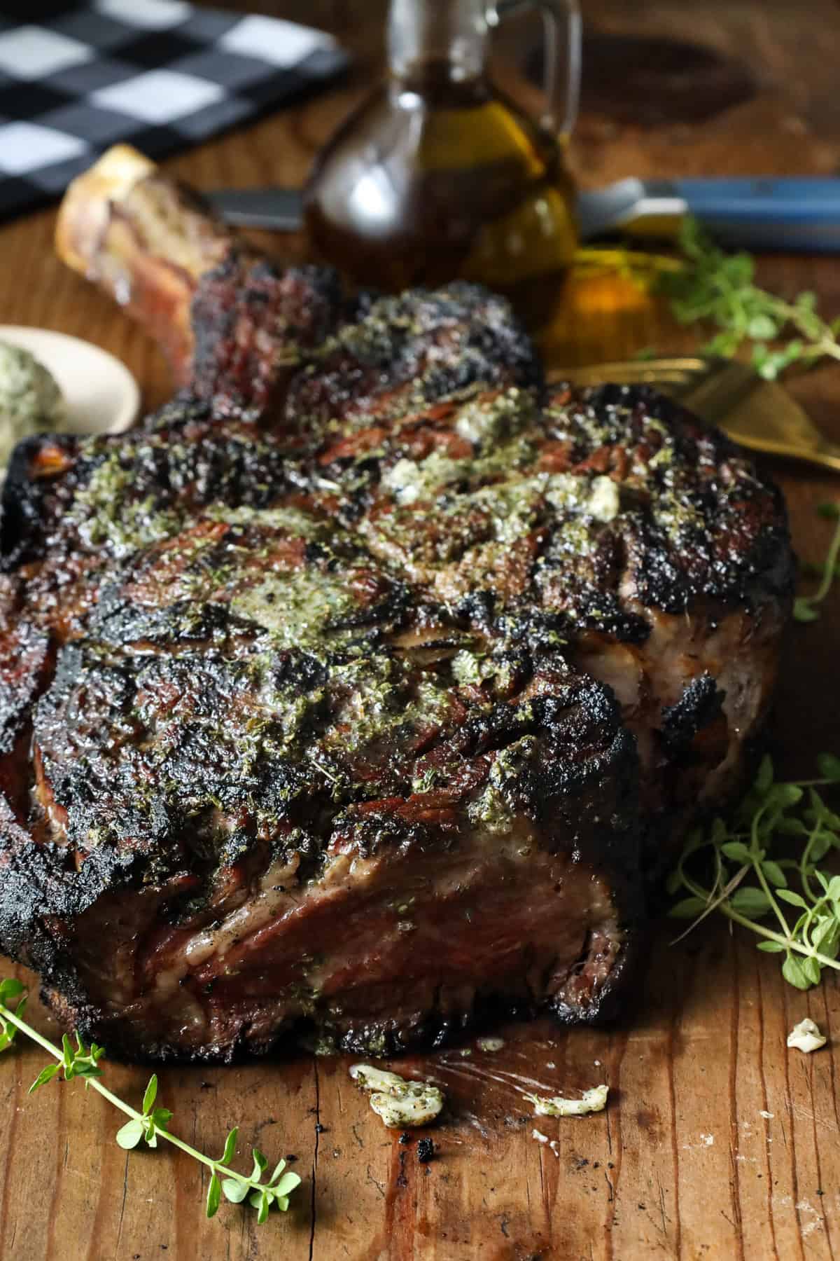 Grilled Cowboy Steak with herbs on a wooden board