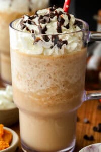 pumpkin spice Frappuccino topped with whipped cream, chocolate chips and chocolate syrup and straw