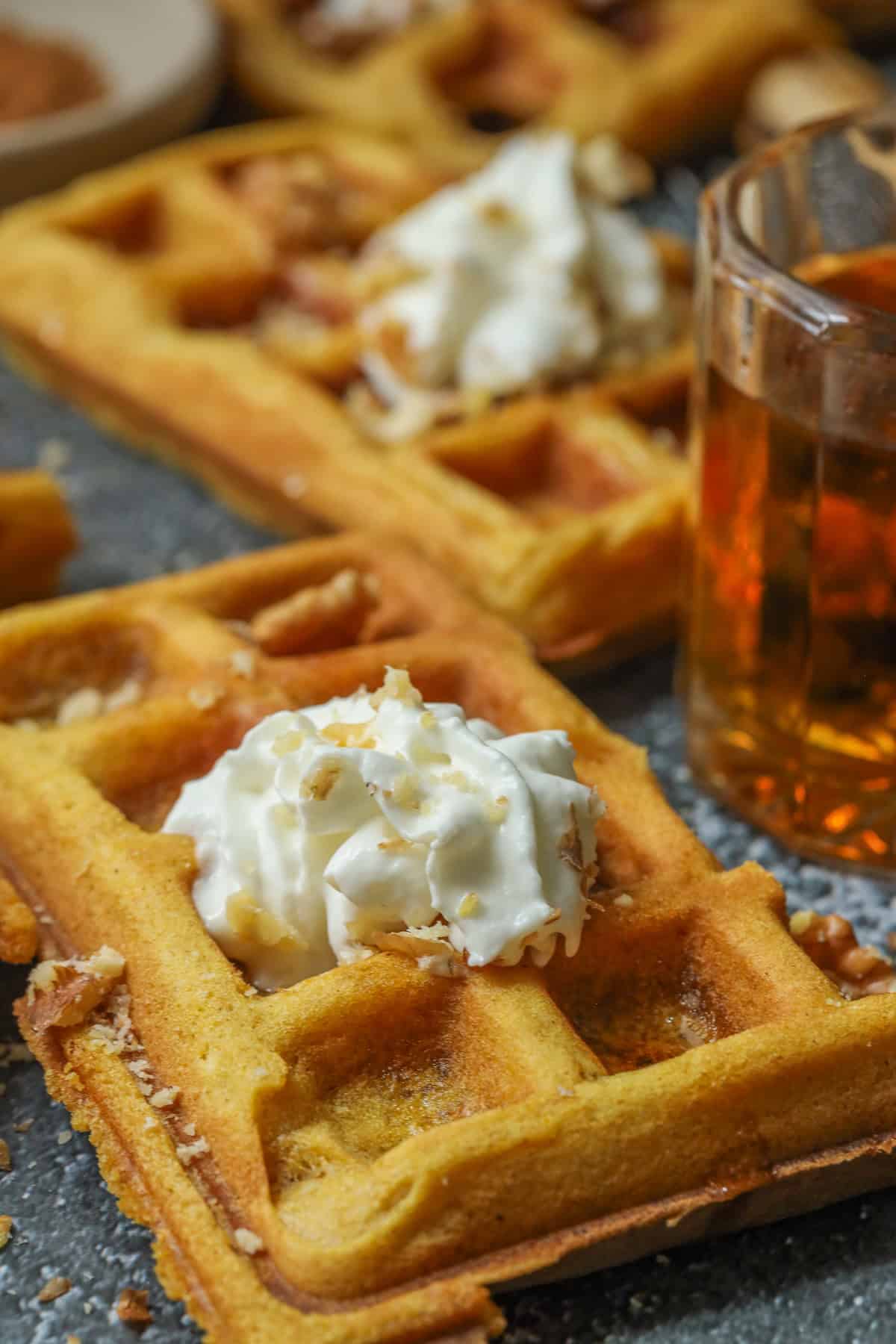 Pumpkin waffles topped with nuts and whipped cream