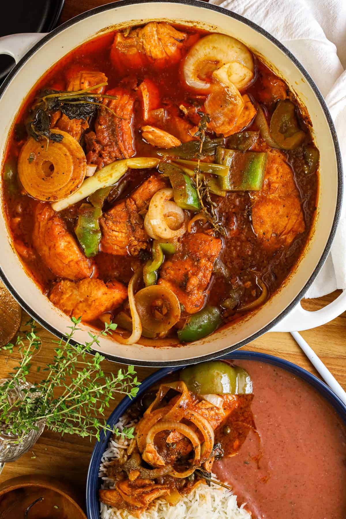 Haitian salmon stew in saucepan mixed with bell peppers and onions.