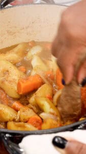 mashing the vegetables to make Haitian Legume militon