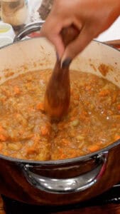 mashing the vegetables to make Haitian Legume militon