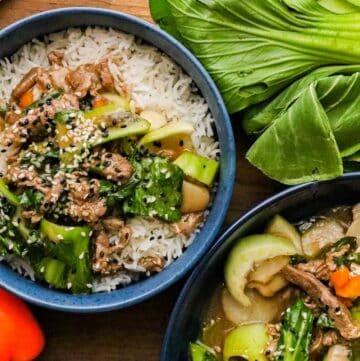 two bowls filled with Bok Choy layered over a bed of white rice