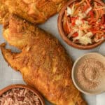 Fried Red Snapper in a tray with Haitian red beans and rice, pikliz, and Jacmel seasoning.