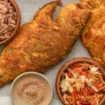 Fried Red Snapper in a tray with Haitian red beans and rice, pikliz, and Jacmel seasoning.