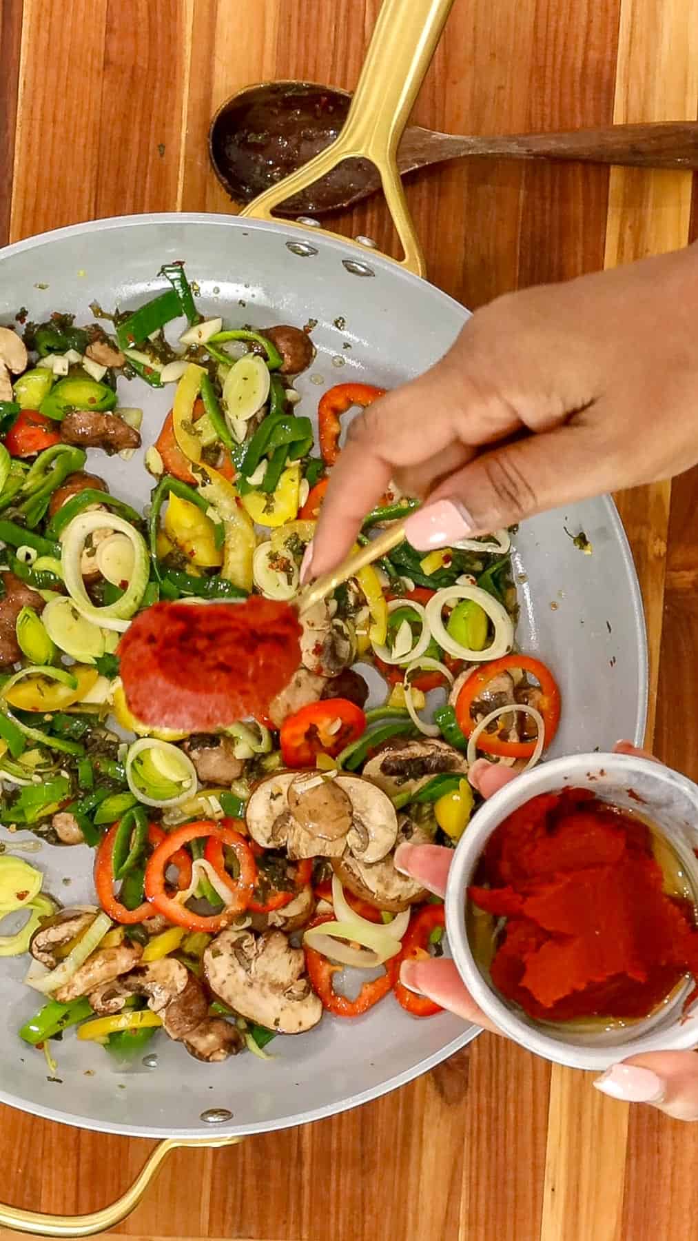 Adding Tomatoes to Sautee Vegetables.