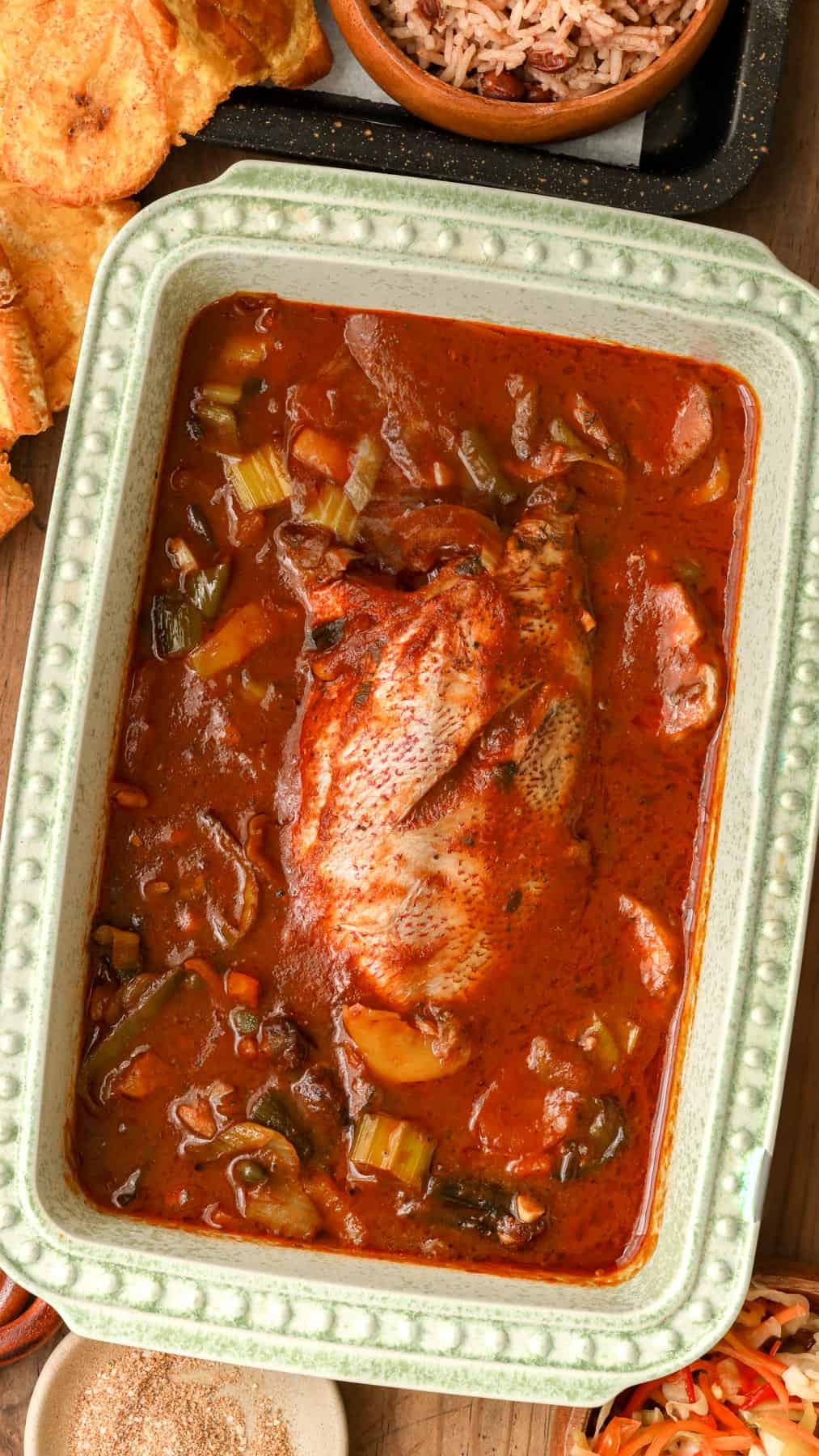 Haitian Fish Stew (Red Snapper Stew) in baking dish with plantains and red beans and rice