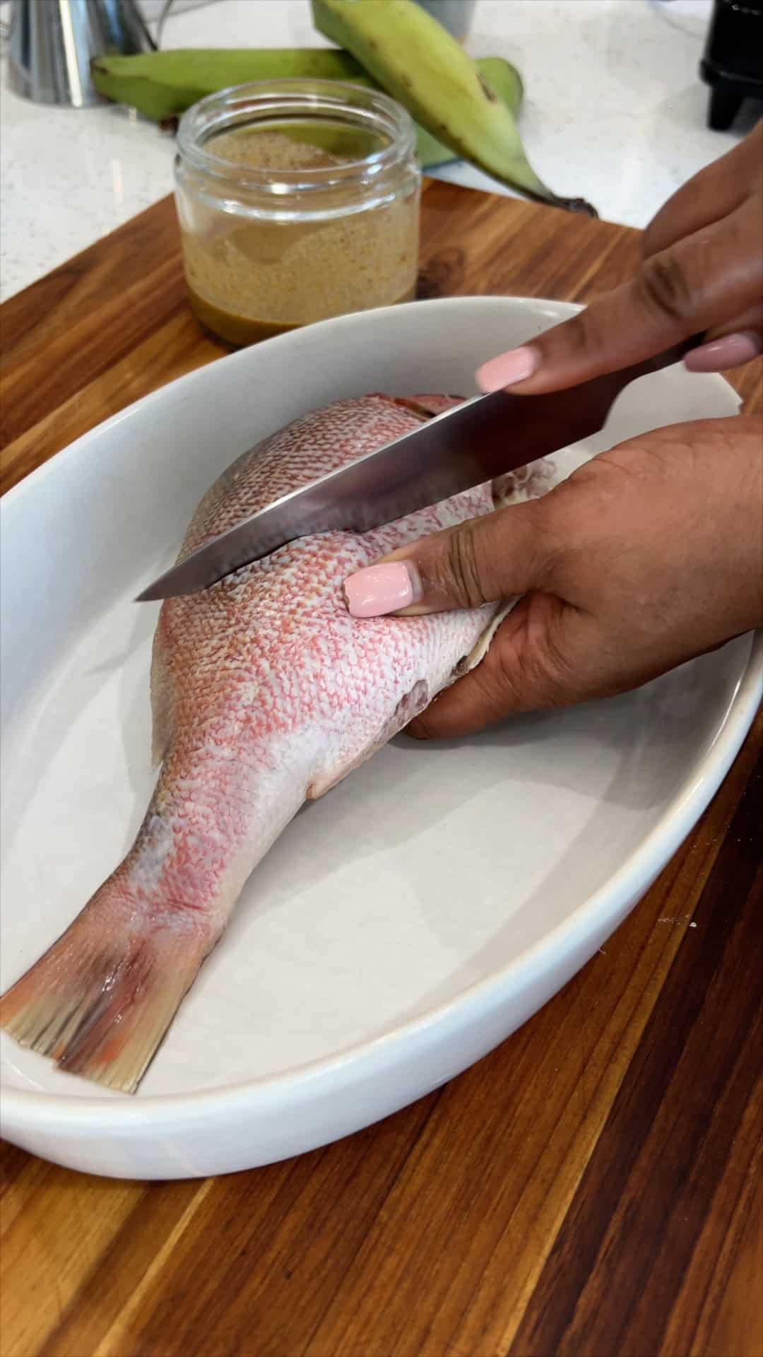 making slits / cutting the red snapper diagonally